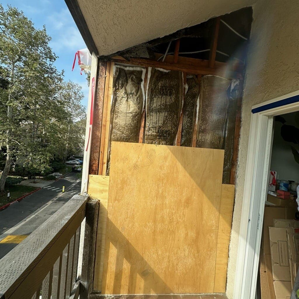 Exterior wall opened to the studs and insulation during termite damage repair